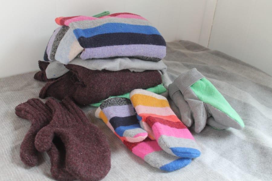 Three pairs of handmade mittens were each constructed from sweaters using slightly different techniques.