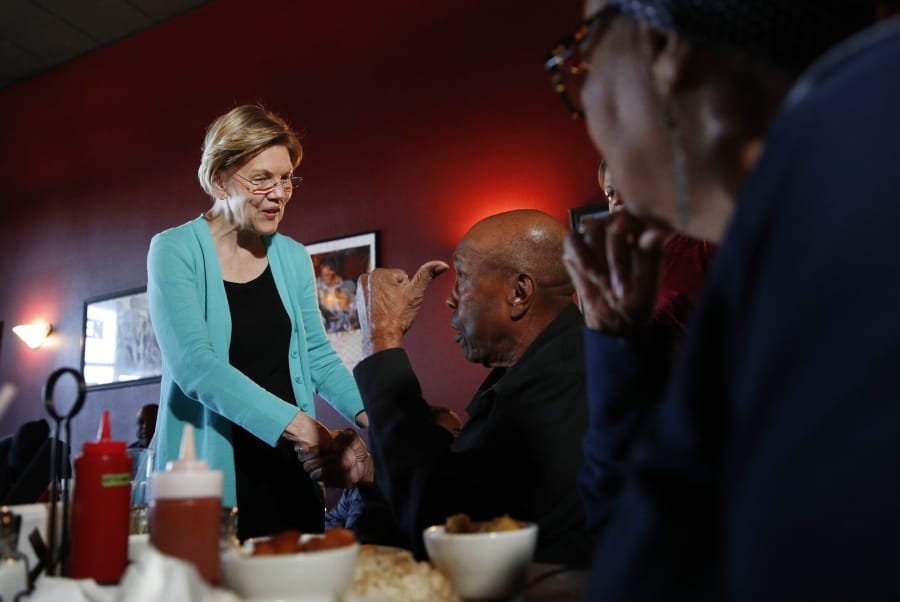 Democratic presidential candidate Sen. Elizabeth Warren, D-Mass., speaks with Bill Mamgum, center, and Shirley Mamgum at EllaEm&#039;s Soul Food, Thursday, Feb. 20, 2020, in North Las Vegas, Nev.