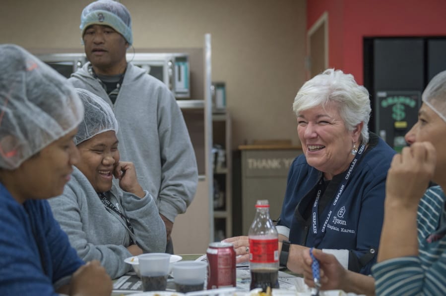 Karen Diefendorf, second from right, director of Chaplain Services at Tyson Foods, talks with employees in 2018 at the company&#039;s Berry Street poultry plant in Springdale, Ark. The company deploys a team of more than 90 chaplains to comfort and counsel employees at its plants and offices. The program began in 2000.