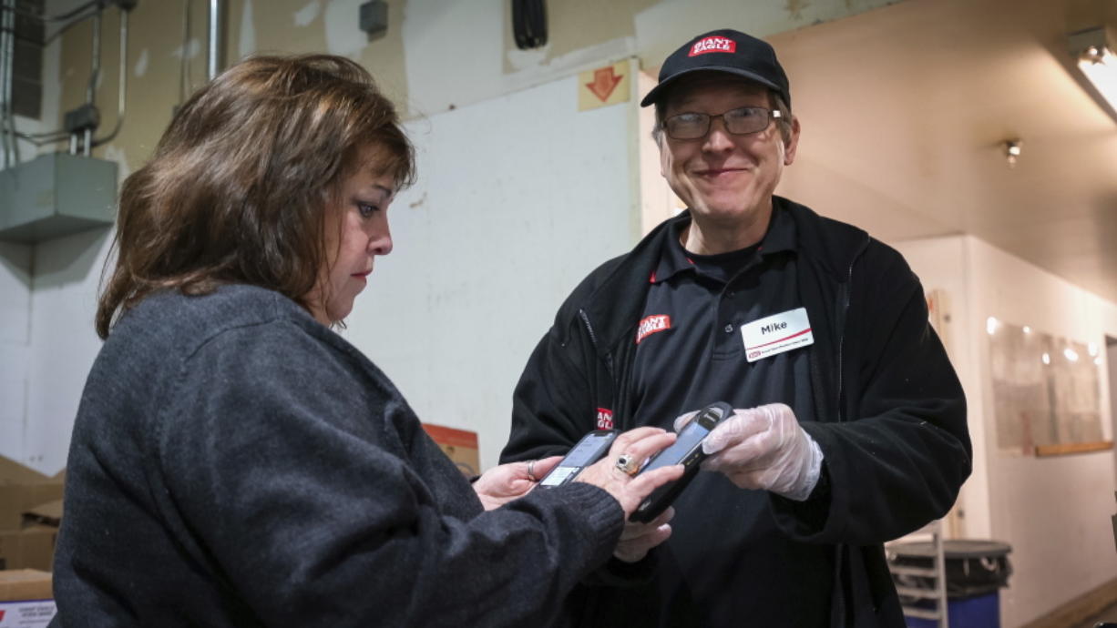 This Oct. 20, 2019 photo released by  412 Food Rescue shows a volunteer using the Food Rescue Hero app to check in at a Pittsburgh grocery store to pick up donated food. While millions of people struggle with food insecurity and hunger nationwide, the USDA estimates that more than 30% of the food in America is wasted each year.