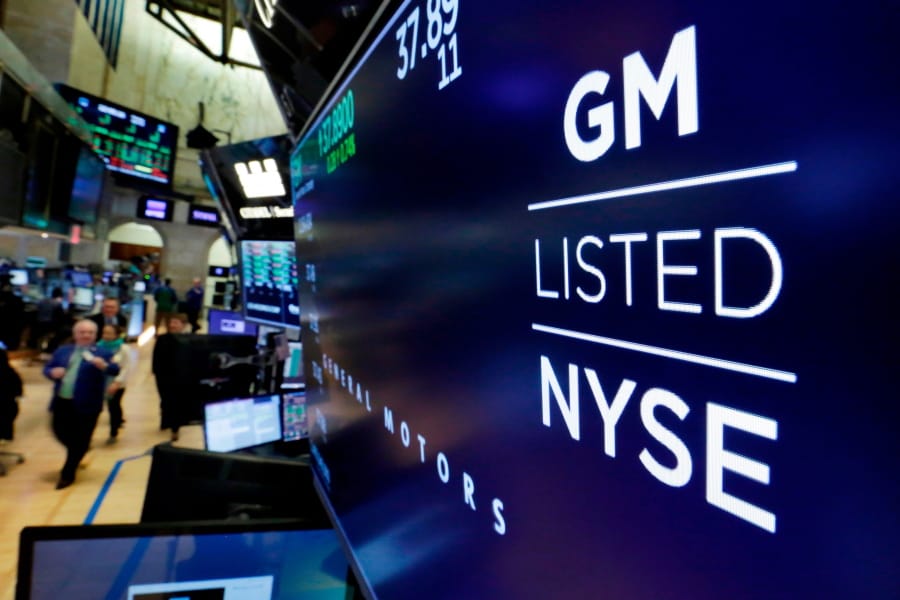 FILE - In this April 23, 2018, file photo, the logo for General Motors appears above a trading post on the floor of the New York Stock Exchange.  Despite a 40-day strike by factory workers and slumping sales in the U.S. and China, General Motors still made money in 2019. The company posted a $6.58 billion profit for the year, but that was down almost 17% from 2018.