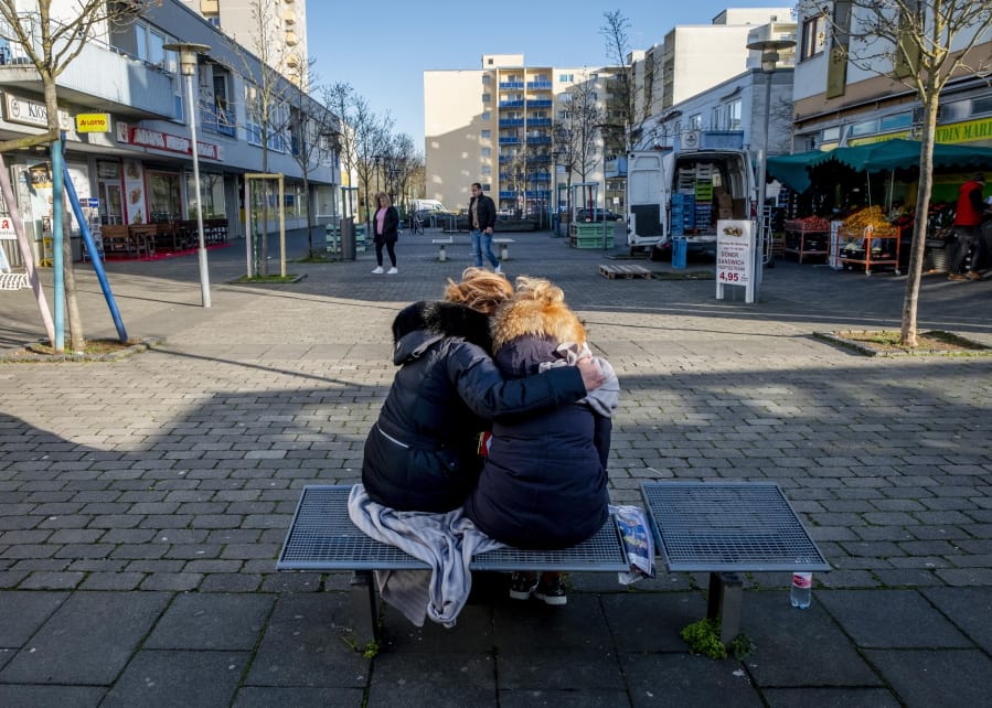 Two woman mourn near a kiosk in Hanau, Germany Friday, Feb. 21, 2020 two days after a 43-year-old German man shot and killed several people at several locations in a Frankfurt suburb on Wednesday, Feb. 19, 2020.