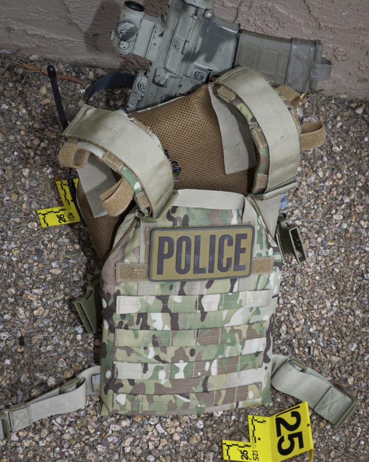 This April 11, 2019 photo provided by the Phoenix Police Department shows a Home Security Investigations agent&#039;s camouflage M4 rifle and armored vest at the scene of an agent-involved shooting in Phoenix, Ariz. The shooting although extreme, was not an isolated incident. Since 2011, there have been at least 13 shootings involving HSI agents &#039;Ai most of them in 2018-19, according to an investigation by the Howard Center for Investigative Journalism.