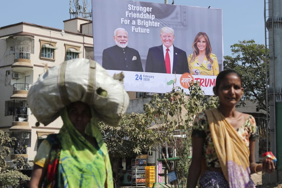 FILE - In this Feb. 18, 2020, file photo, Indian women walk past a hoarding showing Indian Prime Minister Narendra Modi, President Donald Trump and first lady Melania Trump to welcome them ahead of their visit to Ahmadabad, India. Trump is scheduled to visit the city during his Feb. 24-25 India trip. American dairy farmers, distillers and drug makers have been eager to break into India, the world&#039;s seventh-biggest economy but a tough-to-penetrate colossus of 1.3 billion people. Looks like they&#039;ll have to wait. Talks between the Trump administration and New Delhi, intended to forge at least a modest deal in time for President Donald Trump&#039;s visit there, appear to have fizzled. Barring some last-minute dramatics -- always possible with the Trump White House -- a U.S.-India trade pact is months away, if not longer. For now, the failure to reach an accord may reflect not so much the differences between Trump and Prime Minister Narendra Modi as the similarities.