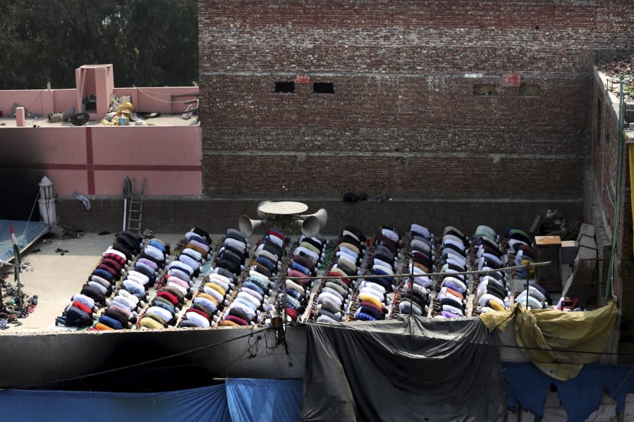 Muslims offer prayers on the roof of a fire-bombed mosque in New Delhi, India, Friday, Feb. 28, 2020. Muslims returned to the battle-torn streets of northeastern New Delhi for weekly prayers at heavily-policed fire-bombed mosques on Friday, two days after a 72-hour clash between Hindus and Muslims that left at least 38 dead and hundreds injured.
