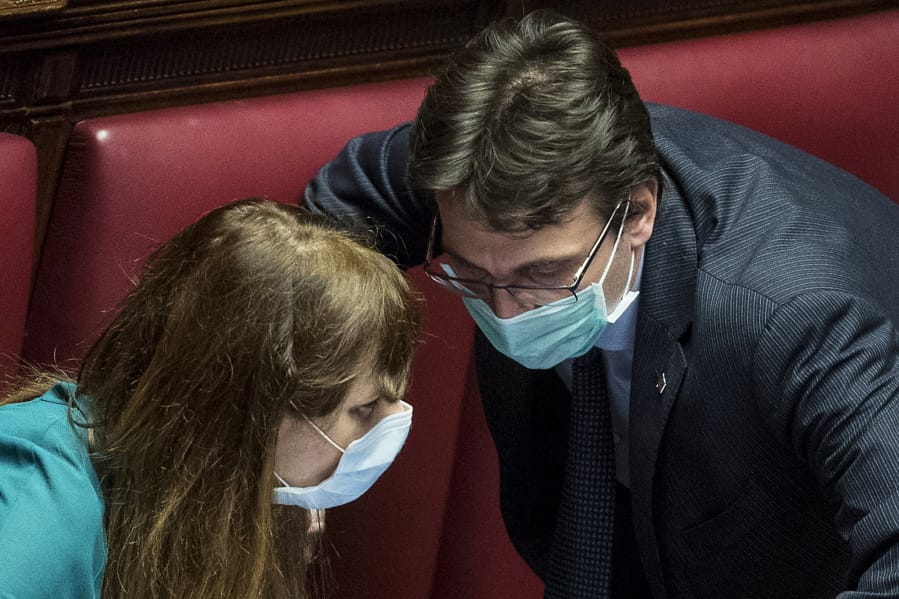 Lawmakers Matteo Dall&#039;Osso, right, and Maria Teresa Baldini wear sanitary mask during a work session in the Italian lower chamber Tuesday, Feb. 25, 2020.  Civil protection officials on Tuesday reported a large jump of cases in Italy, from 222 to 283. Seven people have died, all of them elderly people suffering other pathologies.