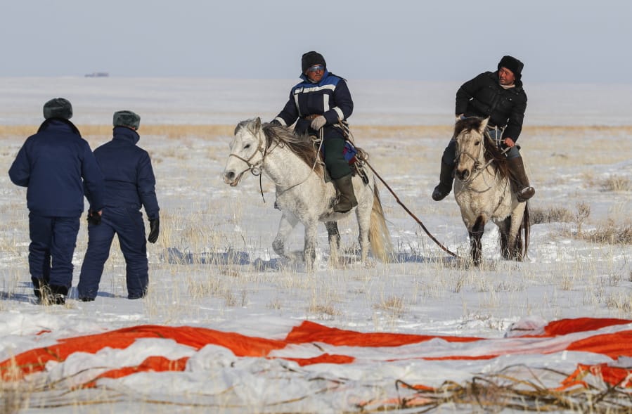 Kazakh shepherds ride near a parachute close to the place where Russian Soyuz MS-13 space capsule landed about 150 km (90 miles) south-east of the Kazakh town of Zhezkazgan, Kazakhstan, Thursday, Feb. 6, 2020. A Soyuz space capsule with U.S. astronaut Christina Koch, Italian astronaut Luca Parmitano and Russian cosmonaut Alexander Skvortsov, returning from a mission to the International Space Station landed safely on Thursday on the steppes of Kazakhstan.