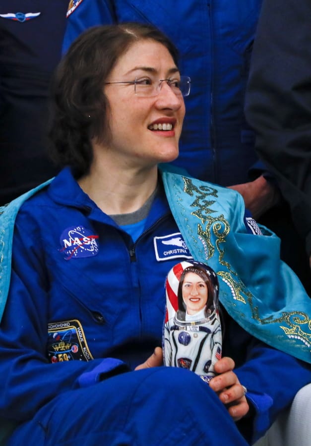U.S. astronaut Christina Koch dressed in a traditional Kazakh national attire, holds a Russian traditional wooden doll Matryoshka depicting her, during a news conference in an airport of Karaganda, Kazakhstan, Thursday, Feb. 6, 2020. A Soyuz space capsule with U.S. astronaut Christina Koch, Italian astronaut Luca Parmitano and Russian cosmonaut Alexander Skvortsov, returning from a mission to the International Space Station landed safely on Thursday on the steppes of Kazakhstan.