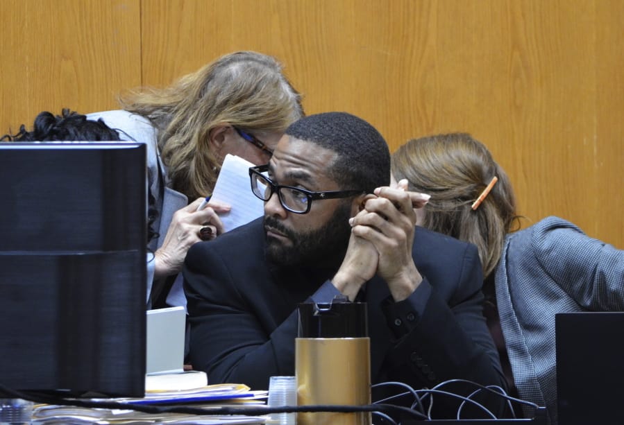 Defense attorneys Alison Steiner, left, and Katherine Poor, right, discuss behind Willie Cory Godbolt during the second day of testimony in the capital murder trial of Godbolt at the Pike County Courthouse in Magnolia, Miss., Sunday, Feb. 16, 2020. Opening arguments were made Saturday in the death penalty trial of Godbolt, accused of killing multiple people in Mississippi in May 2017.