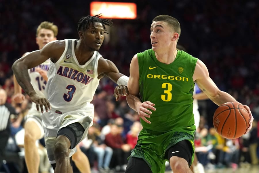 Oregon guard Payton Pritchard, right, drives on Arizona guard Dylan Smith during the first half of an NCAA college basketball game Saturday, Feb. 22, 2020, in Tucson, Ariz.