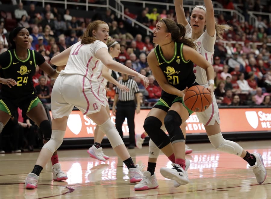 Oregon&#039;s Sabrina Ionescu (20) looks to shoot between Stanford&#039;s Ashten Prechtel (11) and Lexie Hull, right, in the first half of an NCAA college basketball game Monday, Feb. 24, 2020, in Stanford, Calif.