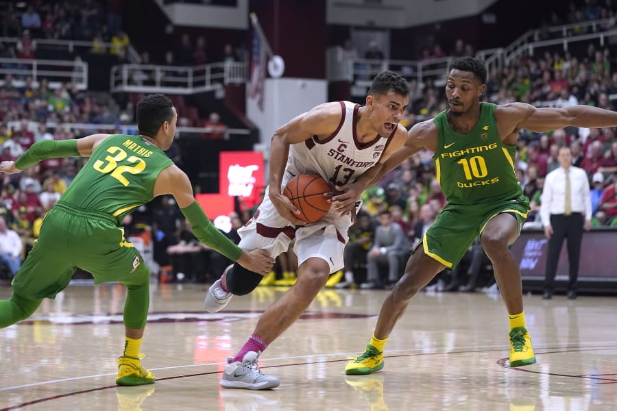 Stanford forward Oscar da Silva (13) dribbles past Oregon guard Anthony Mathis (32) and forward Shakur Juiston (10) during the second half of an NCAA college basketball game Saturday, Feb. 1, 2020, in Stanford, Calif. Stanford won 70-60.