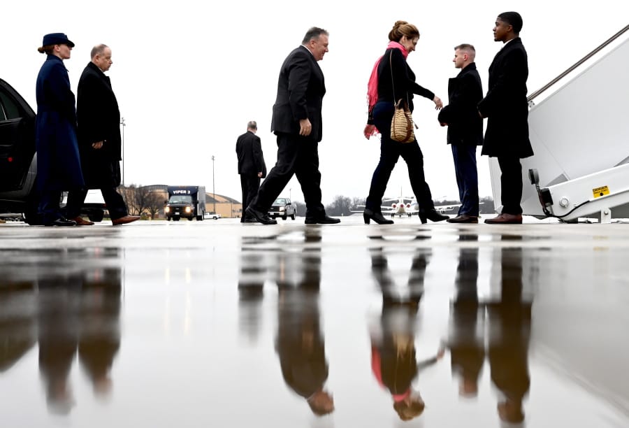 Secretary of State Mike Pompeo, center, walks with his wife Susan, to board a plane as he departs on a multi-country trip, Thursday, Feb. 13, 2020 at Andrews Air Force Base, Md.
