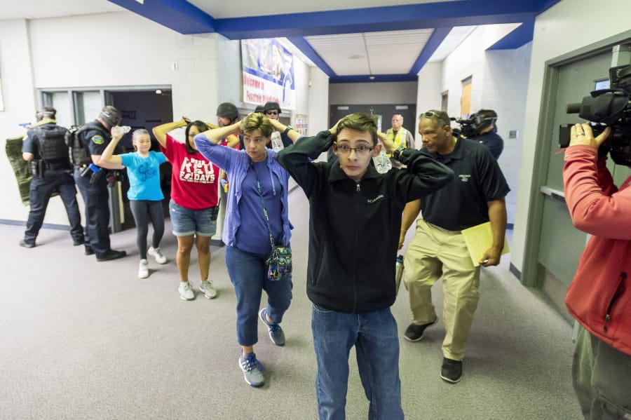 Students are led out of school as members of the Fountain Police Department take part in an Active Shooter Response Training exercise in 2017 at Fountain Middle School in Fountain, Colo.