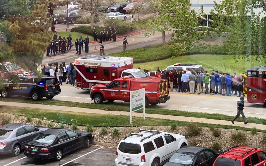 FILE - In this May 7, 2019 file photo, police and students are seen outside STEM School Highlands Ranch, a charter middle school in the Denver suburb of Highlands Ranch, Colo., after a shooting. The younger of two students charged in a school shooting in suburban Denver that killed a classmate has pleaded guilty. Prosecutors say 16-year-old Alec McKinney pleaded guilty on Friday, Feb. 7, 2020 to 17 felonies, including a first-degree murder charge. In December, a judge ruled that McKinney would be prosecuted as an adult in the May 7 shooting at STEM School Highlands Ranch that killed 18-year-old Kendrick Castillo. Devon Erickson has pleaded not guilty to the same charges McKinney faced in the shooting.