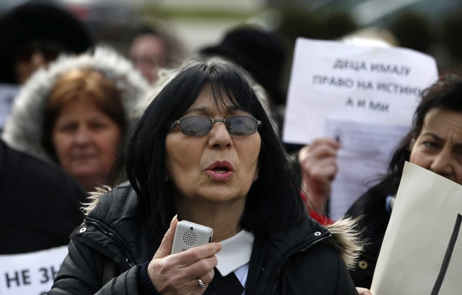 In this photo taken Monday, Feb. 24, 2020, Mirjana Novokmet speaks during a protest in front of the parliament building in Belgrade, Serbia. After years of waiting, Serbian lawmakers are set to soon pass a bill that authorities say attempts to shed light on a chilling, decades-old scandal involving hundreds of families who suspect their babies were stolen at birth. Mirjana Novokmet does not believe that this special law will help uncover what happened to her first child back in 1978.