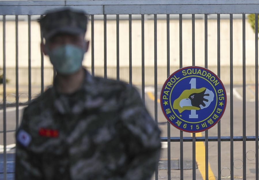 In this Feb. 21, 2020, photo, a South Korean marine wearing a mask stands in front of the Navy Base after a soldier of the unit was confirmed to have been infected with the coronavirus on Jeju Island, South Korea. The U.S. and South Korean militaries, used to being on guard for threats from North Korea, face a new and formidable enemy that could hurt battle readiness: a virus spreading around the world that has infected more than 1,200 people in South Korea.