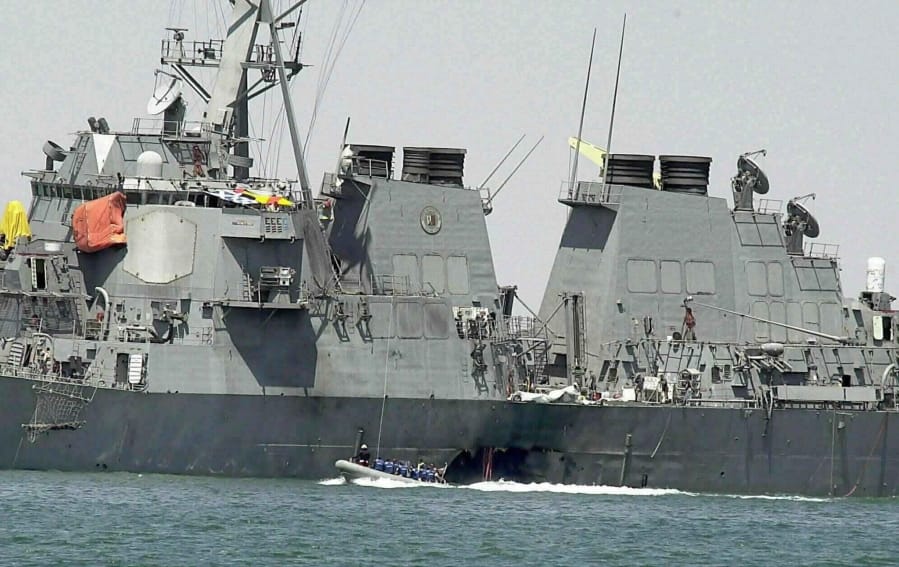 FILE - In this Oct. 15, 2000 file photo, experts in a speed boat examine the damaged hull of the USS Cole at the Yemeni port of Aden after an al-Qaida attack that killed 17 sailors.