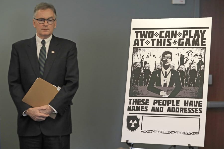 U.S. Attorney Brian Moran stands next to a poster that was mailed earlier in the year to the home of Chris Ingalls, an investigative reporter with KING-TV in Seattle, during a news conference Wednesday in Seattle. (Ted S.