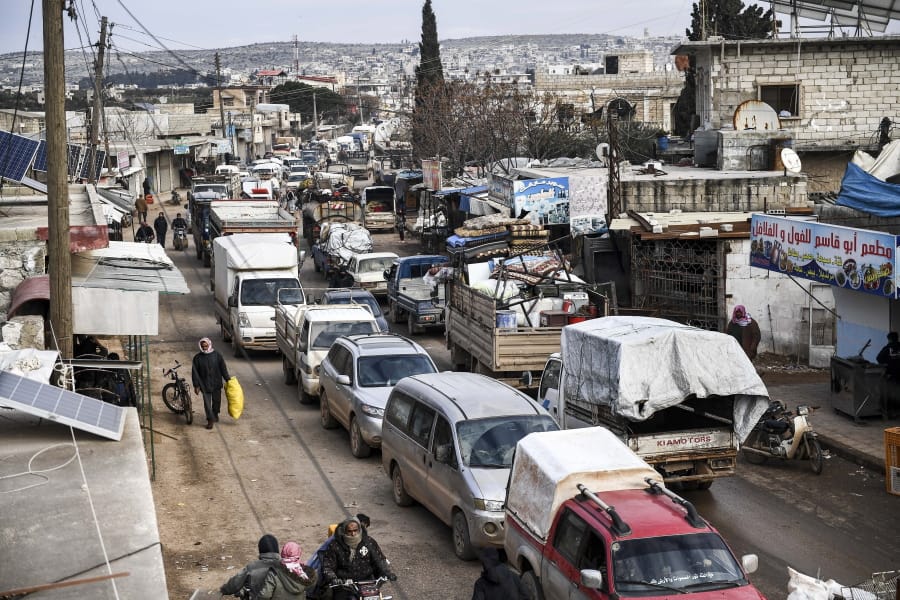 Civilians flee from Idlib toward the north to find safety inside Syria near the border with Turkey, Saturday, Feb. 15, 2020. Syrian troops are waging an offensive in the last rebel stronghold.
