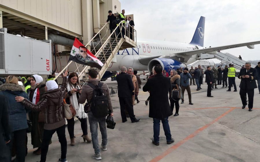 In this photo released by the Syrian official news agency SANA, Syrian officials and journalists disembark a Syrian commercial plane after it landed at Aleppo Airport, Syria, Wednesday, Feb. 19, 2020. The Syrian commercial flight on Wednesday from Damascus, marked the resumption of internal flights between Syria&#039;s two largest cities for the first time since 2012.