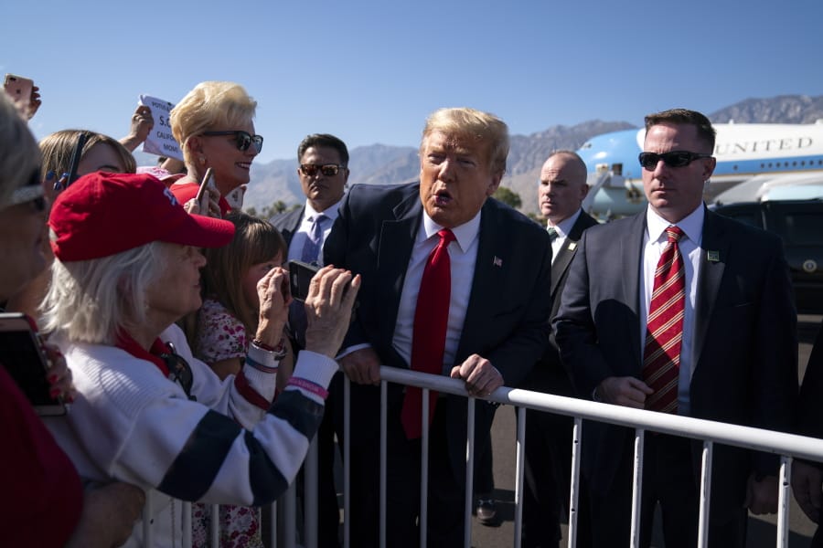 President Donald Trump greets supporters Wednesday at Palm Springs International Airport in Palm Springs, Calif. The president was en route to a fundraiser in Rancho Mirage, Calif.