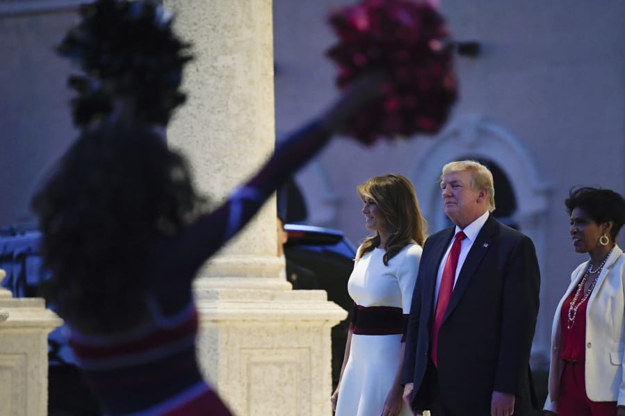 President Donald Trump and first lady Melania Trump watch as the Florida Atlantic University Marching Band performs during a Super Bowl party at the Trump International Golf Club in West Palm Beach, Fla., Sunday, Feb. 2, 2020.