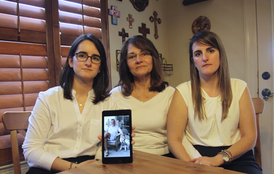 FILE - In this Feb. 15, 2019 file photo, Dennysse Vadell sits between her daughters Veronica, right, and Cristina holding a digital photograph of father and husband Tomeu who is currently jailed in Venezuela with five other  executives from Houston-based Citgo, in Katy, Texas, Friday. According to a family member of one of the other arrested men, they were rounded up while under house arrest in Venezuela on Feb. 5, 2020 by SEBIN intelligence police hours after President Donald Trump met Venezuelan President Nicolas Maduro&#039;s chief opponent at the White House.