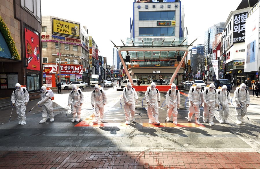 South Korean army soldiers wearing protective suits spray disinfectant to prevent the spread of the COVID-19 virus on a street in Daegu, South Korea, Thursday, Feb. 27, 2020. As the worst-hit areas of Asia continued to struggle with a viral epidemic, with hundreds more cases reported Thursday in South Korea and China, worries about infection and containment spread across the globe.