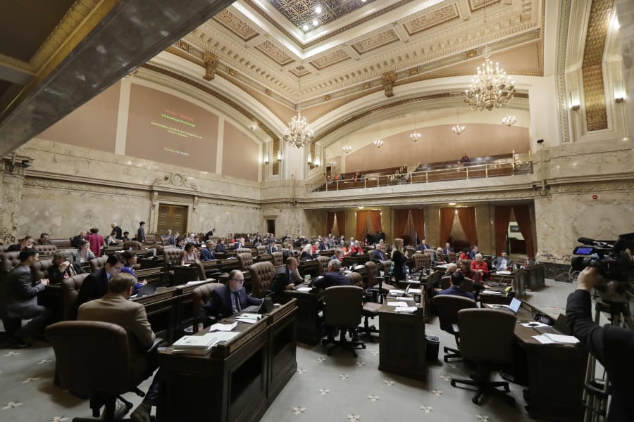 Lawmakers work on the House floor, Wednesday, Feb. 19, 2020, at the Capitol in Olympia. (AP Photo/Ted S.