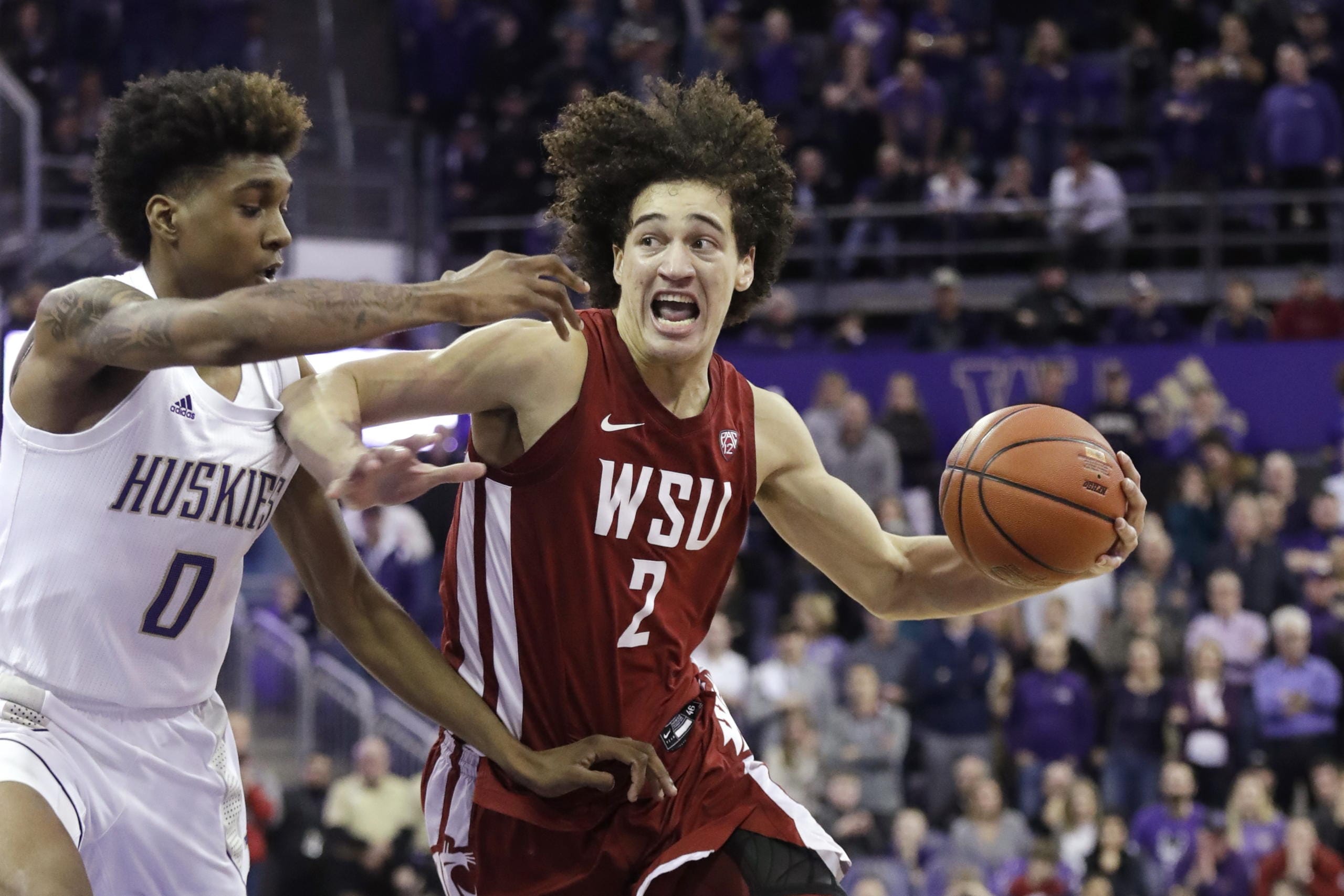 Washington State's CJ Elleby (2) drives against Washington's Jaden McDaniels (0) during the second half of an NCAA college basketball game Friday, Feb. 28, 2020, in Seattle. Washington State won 78-74.