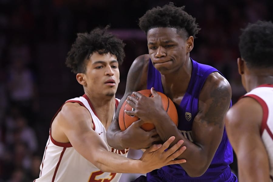 Southern California forward Max Agbonkpolo, left, ties up Washington guard Nahziah Carter during the first half of an NCAA college basketball game Thursday, Feb. 13, 2020, in Los Angeles. (AP Photo/Mark J.