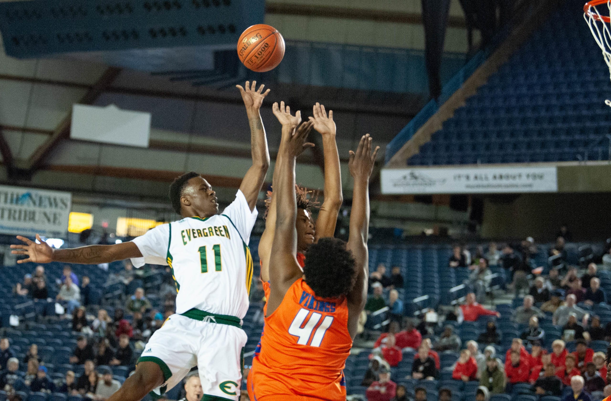 Evergreen's Mario Herring lifts a floater over a pair of Rainier Beach defenders in a 3A round of 12 game on Wednesday at the Tacoma Dome.