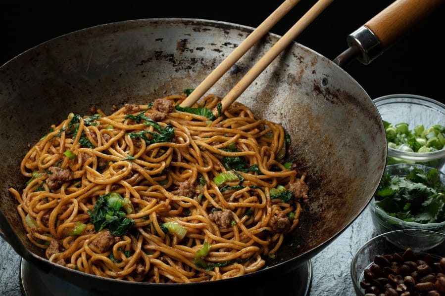 Noodles are tossed in an oil flavored with Sichuan peppercorns, then finished with peanuts, green onions, cilantro, garlic and more peppercorns but this time ground into a powder. (E.