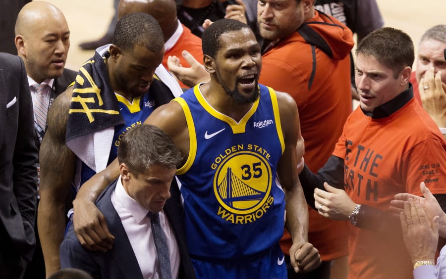 FILE - In this June 10, 2019, file photo, Golden State Warriors forward Kevin Durant (35) reacts as he leaves the court after sustaining an injury during first-half basketball action against the Toronto Raptors in Game 5 of the NBA Finals in Toronto. Durant is headed to the Brooklyn Nets, leaving the Warriors after three seasons. His decision was announced Sunday, June 30, 2019, at the start of the NBA free agency period on the Instagram page for The Boardroom, an online series looking at sports business produced by Durant and business partner Rich Kleiman.