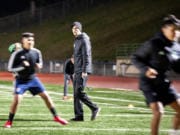 Mountain View coach Dustin Johnson walks through a conditioning drill during a late-night practice on March 11 at McKenzie Stadium.