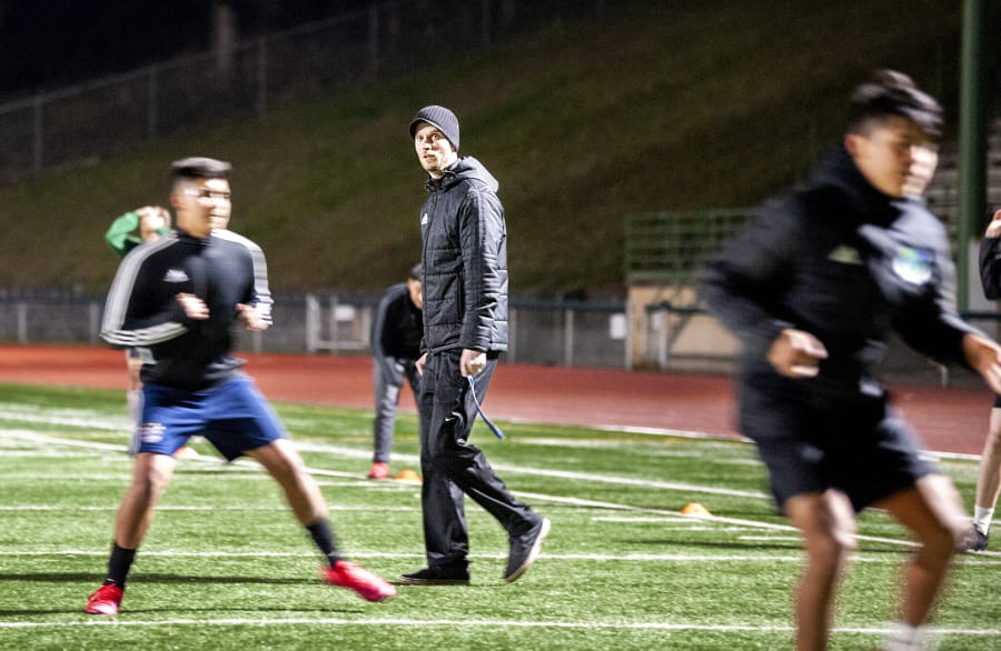 Mountain View coach Dustin Johnson walks through a conditioning drill during a late-night practice on March 11 at McKenzie Stadium.
