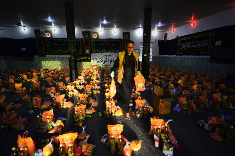 A man sorts donations for families in need in the central Iraqi holy city of Najaf on Wednesday, March 25, 2020 amid the COVID-19 coronavirus pandemic.