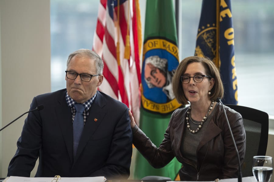 Washington Gov. Jay Inslee and Oregon Gov. Kate Brown talk to reporters before signing a memorandum of intent to replace the Interstate 5 Bridge during an event in November at the Murdock Charitable Trust in Vancouver. The governors have taken on bigger responsibilities during the coronavirus pandemic, which has lacked an efficient, uniform federal response.