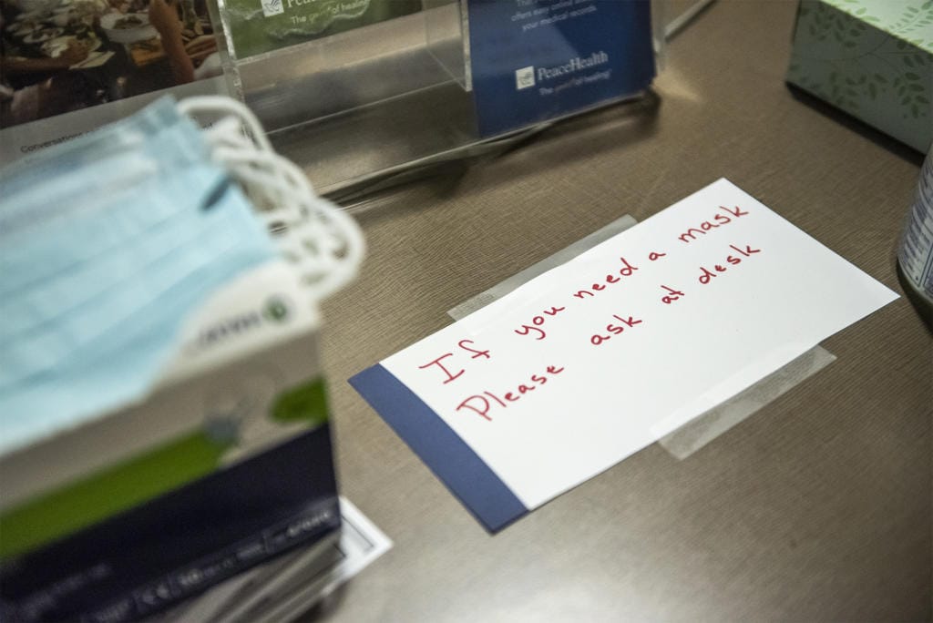 A sign directing visitors to the front desk if they are in need of a mask is seen here at PeaceHealth Southwest Medical on Monday afternoon, March, 2, 2020.