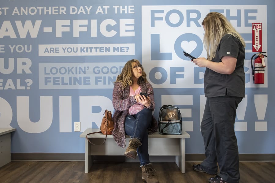 Cheryl Collins, left, and her daughter&#039;s cat Barney check in with Clinic Assistant Nicole Akerill at the VetIQ location inside the 221E N.E. 104th Ave. Walmart in Vancouver.