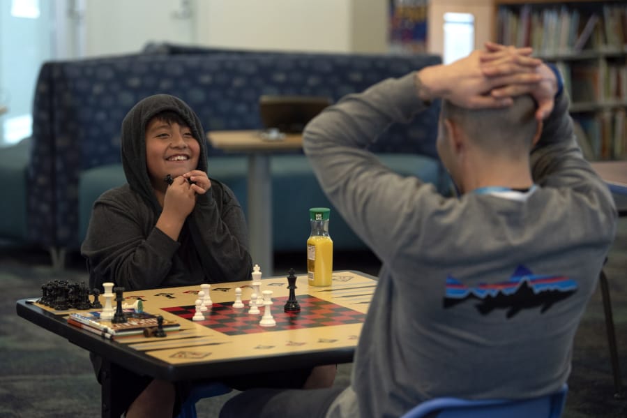 Luis, 10, reacts as he wins a game of chess against his mentor, Brian Kay, on Wednesday at Cascade Park Community Library in Vancouver. The duo were paired through Friends of the Children, a mentoring program that started in Portland in 1993.
