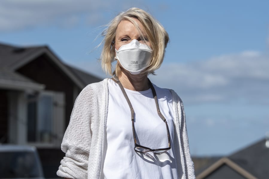 Lisa Bayautet wears her N95 face mask near her Vancouver home. Bayautet takes medication for psoriatic arthritis that suppresses her immune system, making her especially vulnerable to illness in her daily life.