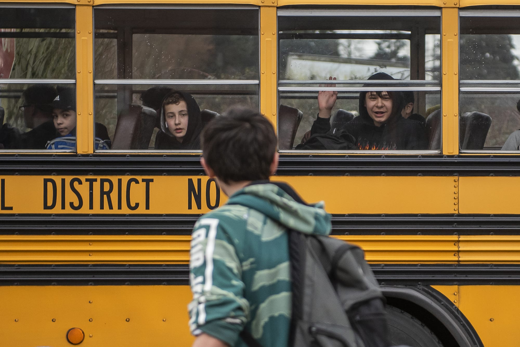 Students wave to Owen Watts, foreground, as their bus pulls away from Covington Middle School on Friday afternoon, March 13, 2020.