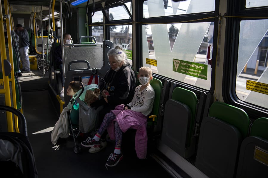 Linda Hilley of Vancouver rides The Vine on Wednesday with her grandchildren, Cali, 11, back left, Reno, 6, center, and Justice, 8, right. C-Tran reported a drop in ridership but has not reduced its routes. Hilley said she is watching her grandchildren because schools have been closed due to the novel coronavirus pandemic, and their parents are still working.