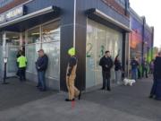 Customers stand in line outside Main Street Marijuana in downtown Vancouver on Monday afternoon. Employees placed strips of red duct tape on the ground inside and outside the store to help guide visitors to maintain the recommended 6-foot distances between them to reduce the risk of spreading COVID-19.