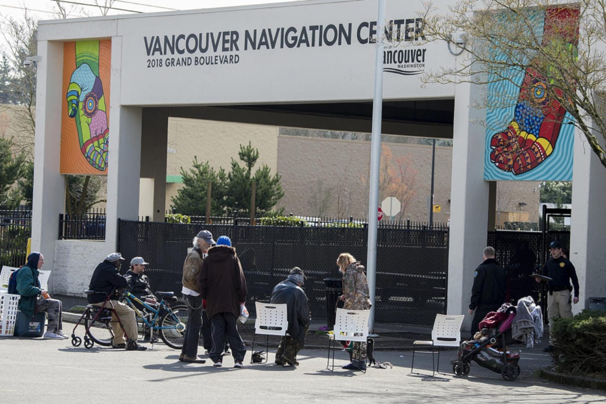 People form a line outside the Vancouver Navigation Center as they wait for their turn to come inside on Wednesday. Only 50 people at a time were allowed inside, an attempt to create more space between clients because of COVID-19 concerns.