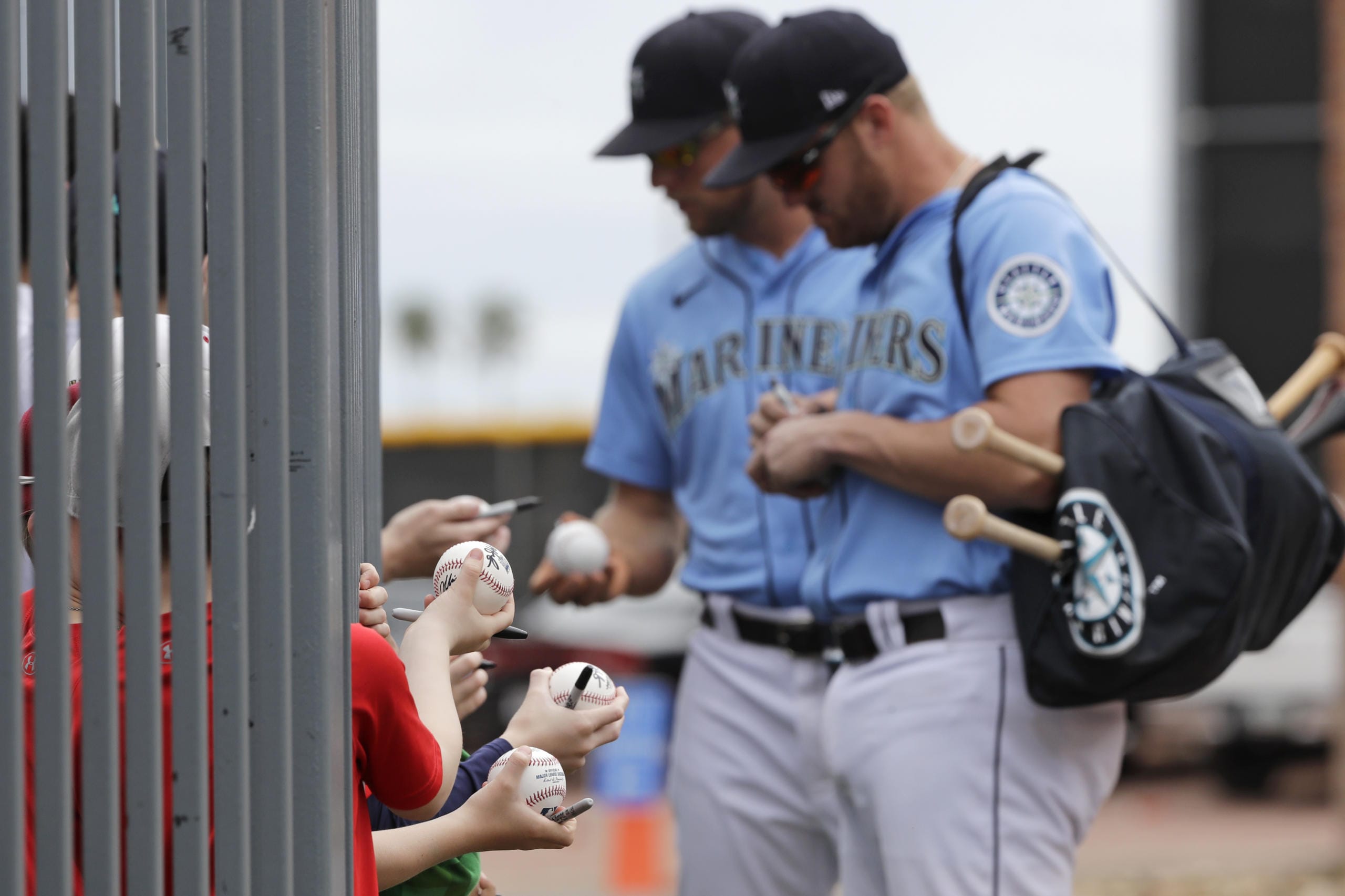 Seattle Mariners' Connor Lien, left, and Mitch Nay stop to sign autographs before a spring training baseball game against the Los Angeles Angels on Tuesday, March 10, 2020, in Peoria, Ariz.