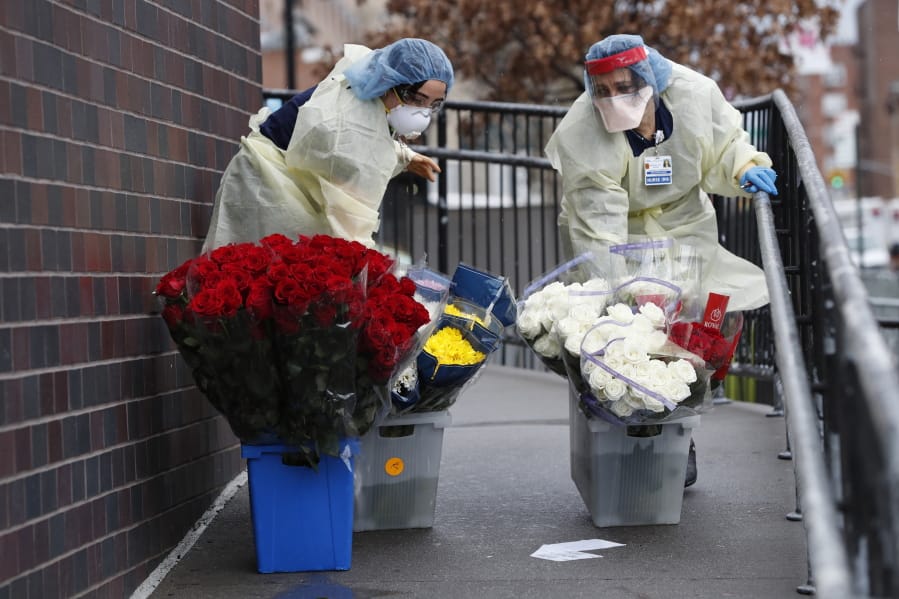Emergency room nurses transport buckets of donated flowers up a ramp outside Elmhurst Hospital Center&#039;s emergency room, Saturday, March 28, 2020, in New York. The hospital has been heavily taxed by treating an influx of coronavirus patients during the current viral pandemic. Currently, New York leads the nation in the number of cases, according to Johns Hopkins University, which is keeping a running tally.