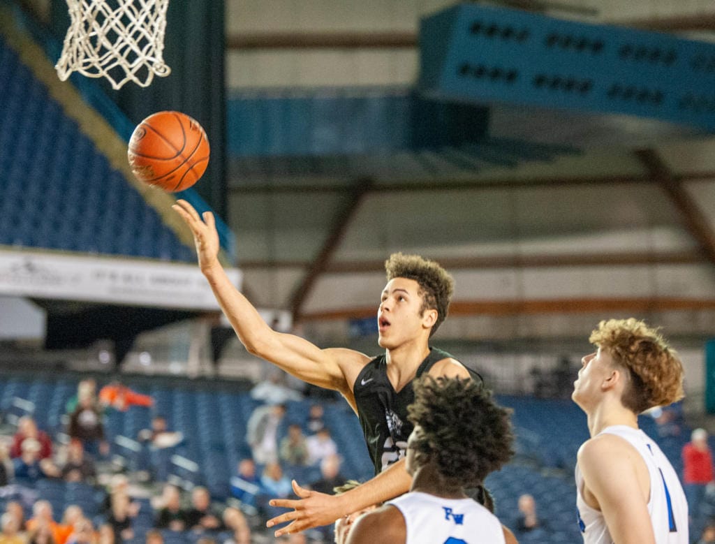 Battle Ground's Kaden Perry lofts the ball off the backboard to himself for a dunk in a 4A State round-of-12 game Wednesday at the Tacoma Dome.